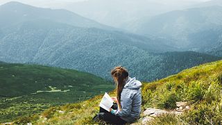 Reading climate fiction on the top of a mountain