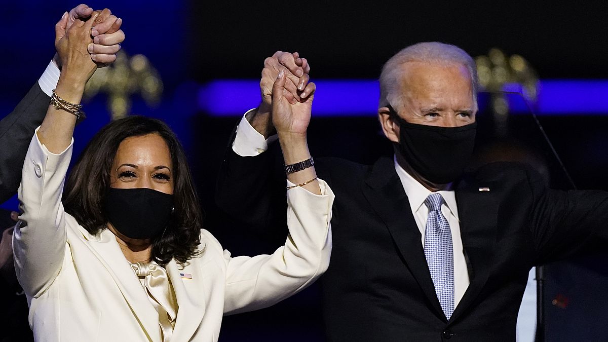 Vice President-elect Kamala Harris holds hands with President-elect Joe Biden and her husband Doug Emhoff as they celebrate Saturday, Nov. 7, 2020, in Wilmington, Delaware.