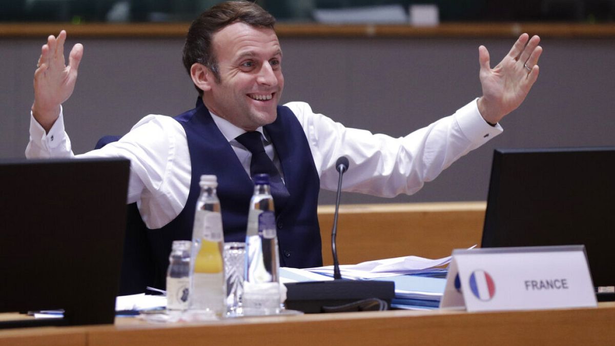 France's Macron gestures after an all night negotiating session at the EU summit saw agreement on cutting the bloc's greenhouse gas emissions by at least 55% by 2030