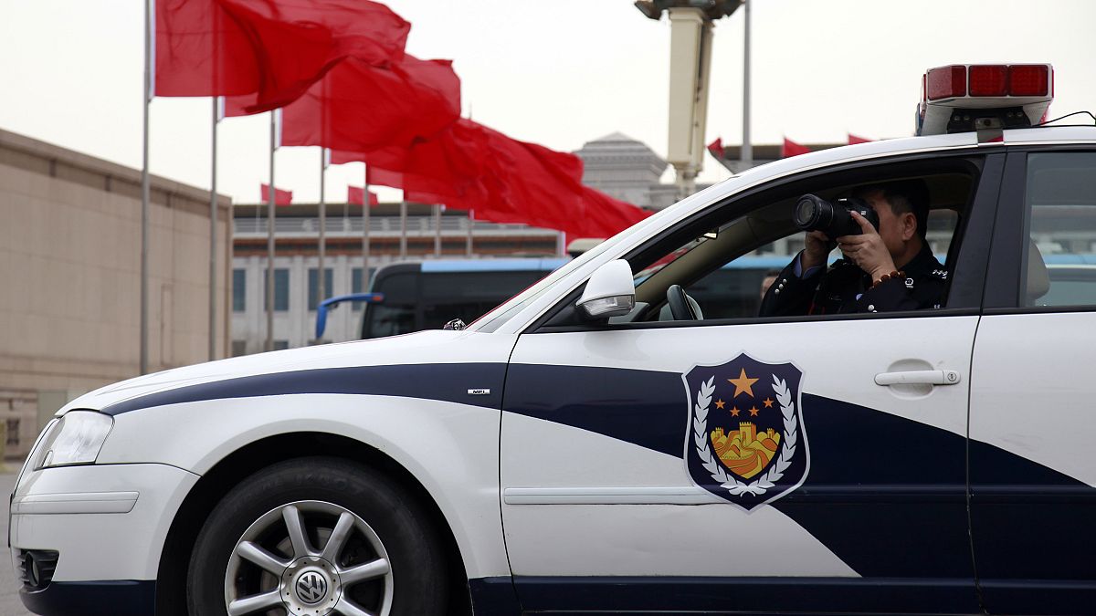 Aracının içinden fotoğraf çeken bir polis memuru, Pekin / Çin