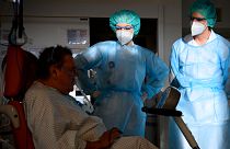 Médico militar ajuda fisioterapeuta em hospital de Genebra a mobilizar doente Covid