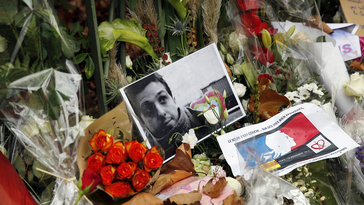 صور الضحايا والزهور والشموع أمام قاعة الحفلات الموسيقية الباتاكلان  في باريس