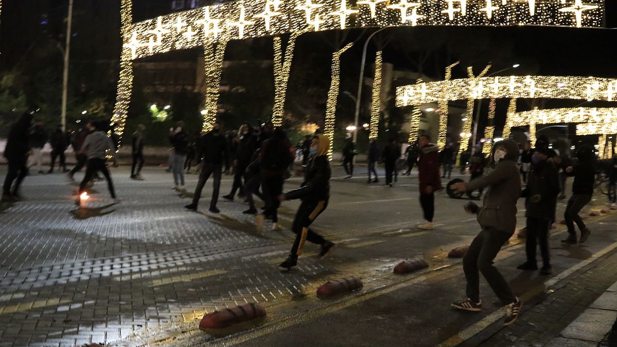 Protesters throw stones to riot police during clashes in Tirana