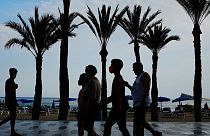 Un grupo de turistas, con mascarillas para prevenir la propagación del coronavirus, camina al lado de la playa en Benidorm, en el sudeste de España.