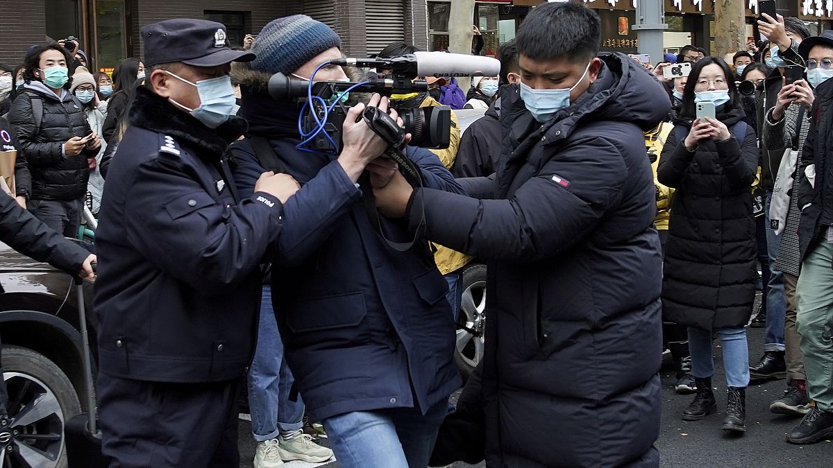FILE PHOTO: A foreign journalist is blocked by Chinese policemen