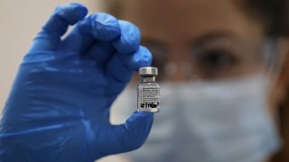 İngiltere'nin başkenti Londra'da bir hastanede Pfizer-BionTech aşısını elinde tutan bir hemşire