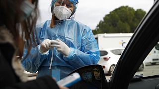 Medical personnel prepares to conduct a COVID-19 rapid test at a drive-through testing site in Athens