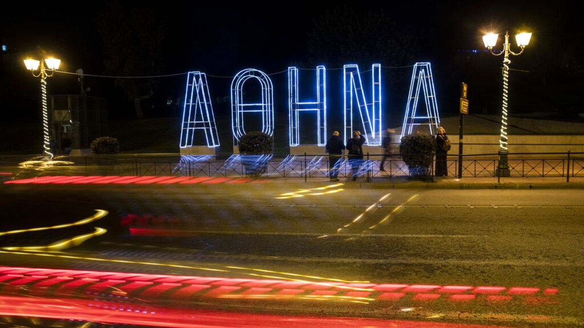 Light tracks of passing cars are seen in front of a Christmas installation in Athens