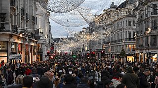Crowds of shoppers walk under the Christmas lights in Regent Street