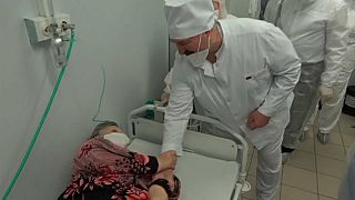 Lukashenko, con la mascherina abbassata, stringe la mano a una paziente Covid