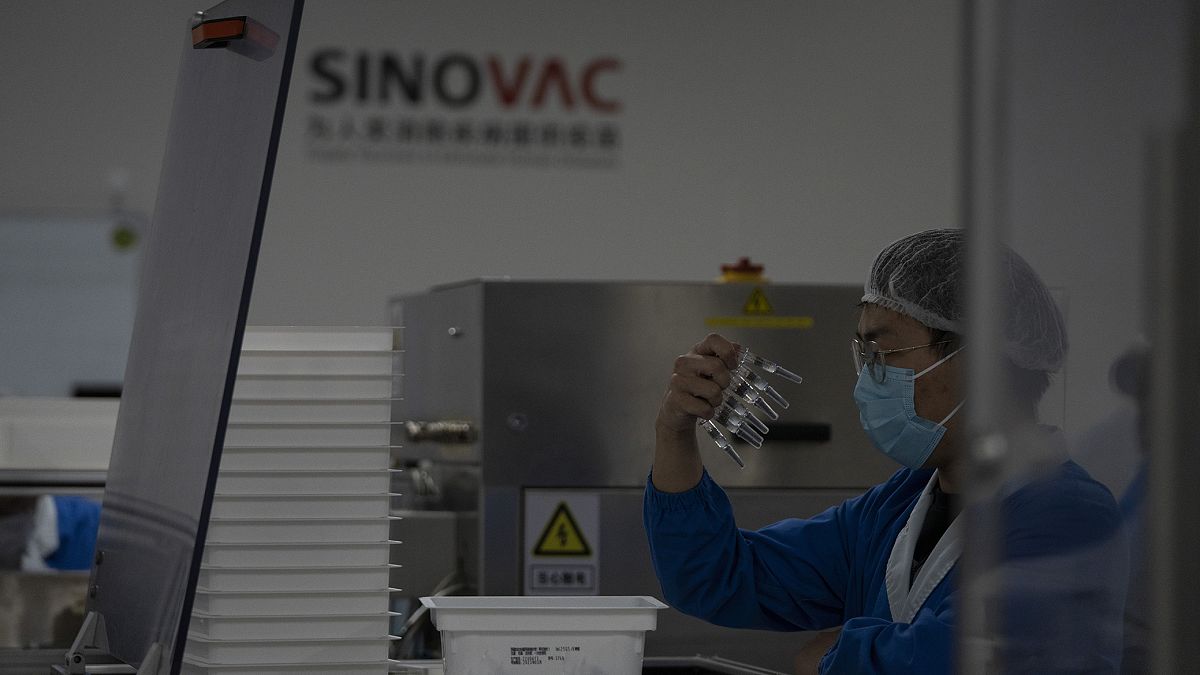 Çinli Sinovac ilaç firmasına ait bir fabrikada görevli şahıs, üretilen şırıngaları incelerken 