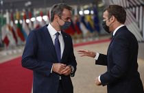 French President Emmanuel Macron, right, speaks with Greek Prime Minister Kyriakos Mitsotakis