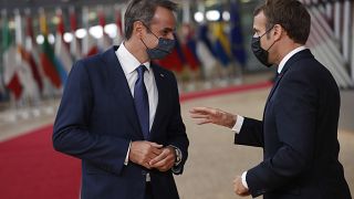 French President Emmanuel Macron, right, speaks with Greek Prime Minister Kyriakos Mitsotakis