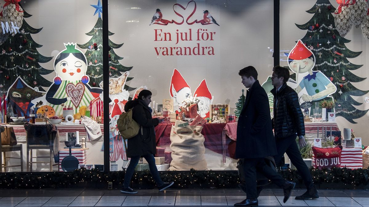 People walk past a Christmas themed shop window in central Stockholm, Sweden, Tuesday Nov. 10, 2020.