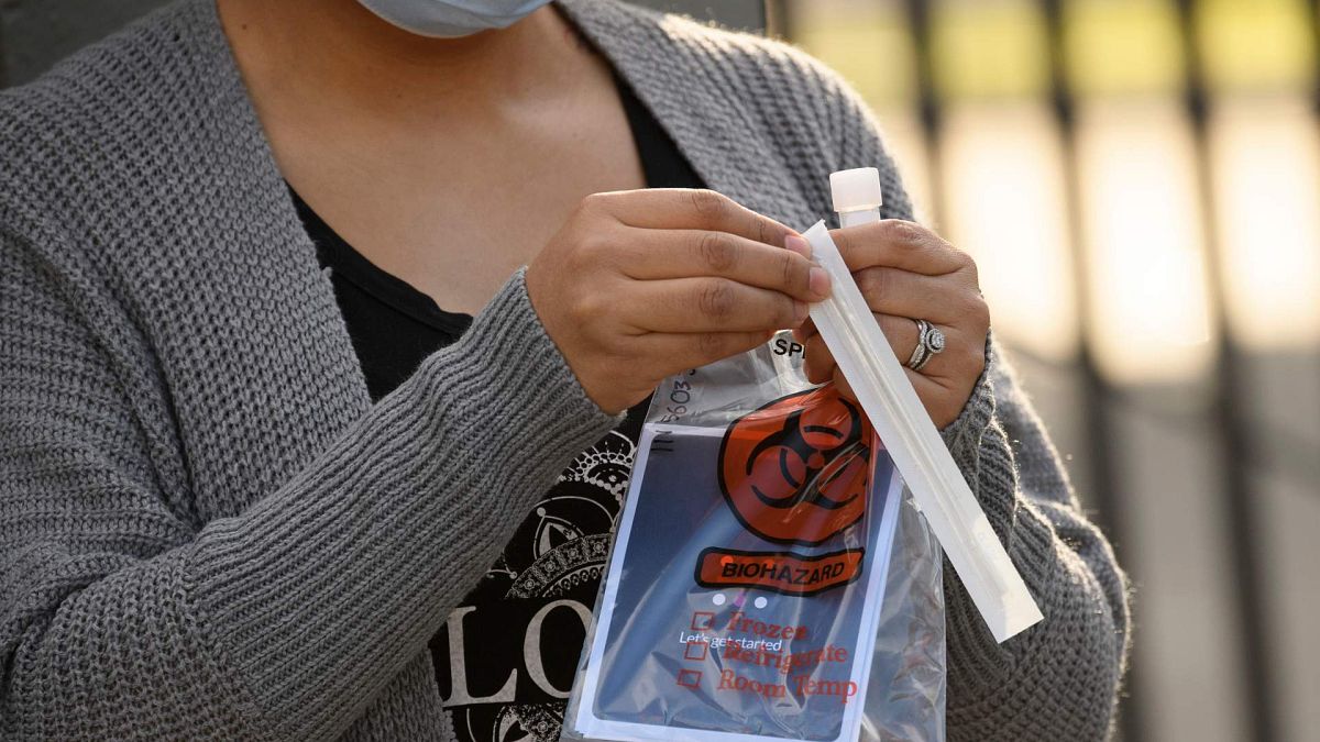 امرأة تفتح اختبار كوفيد-19 عن طريق الفم في لوس أنجلوس، كاليفورنيا، 9 ديسمبر 2020