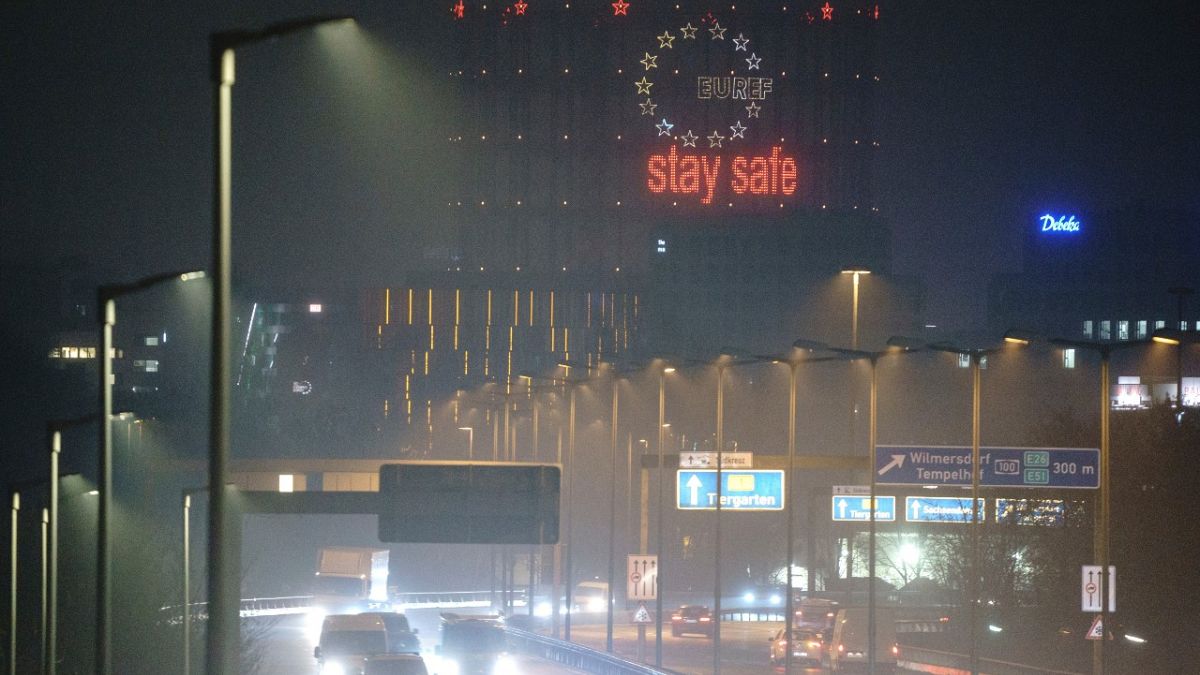 Vehicles drive past the gasometer with the neon sign "Stay Safe" on the city highway in the morning rush hour, in Berlin, Germany, Wednesday, Dec. 16, 2020.