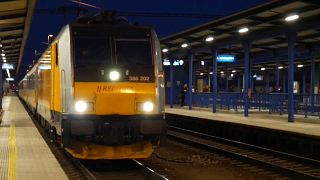 A night train to Prague pulls in to Vienna station. 