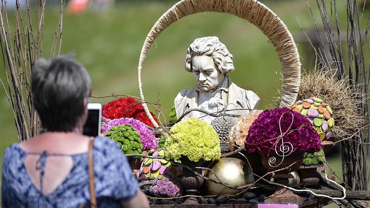 Una escultura del compositor clásico alemán Beethoven se exhibe entre flores en Kamp-Lintfort, Alemania, el 12 de junio de 2020. 