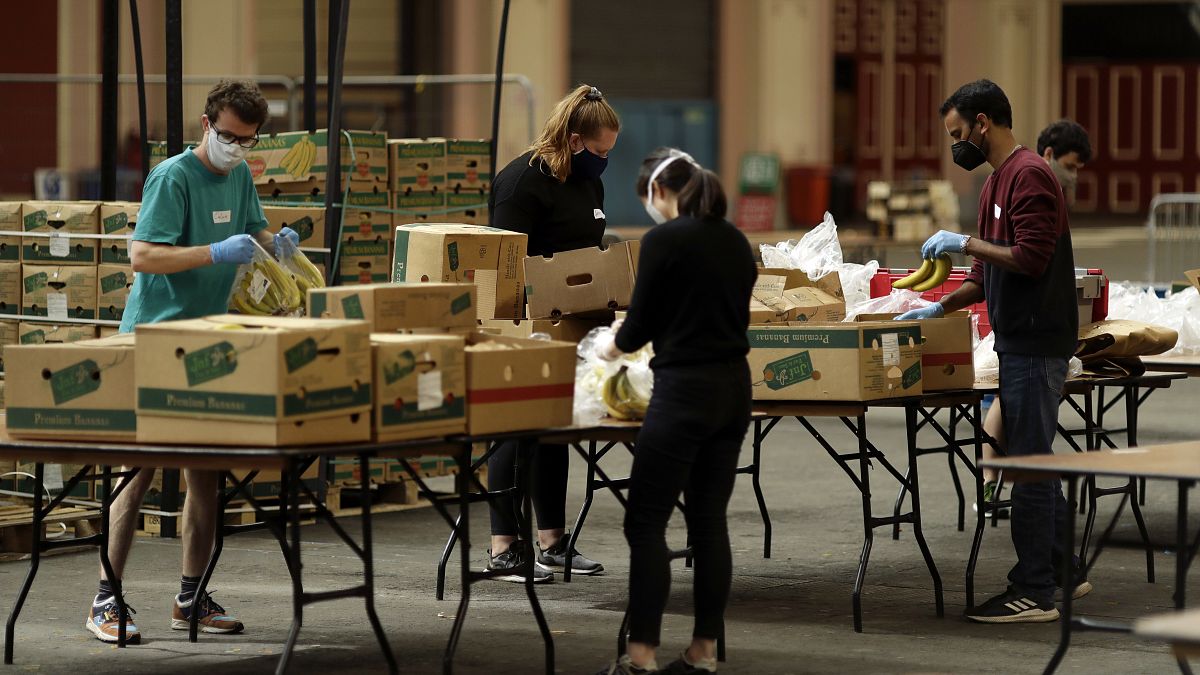 Volunteers check the quality of donated food to be put in packs delivered to residents who need it in the Haringey Council area, London, April 2020.