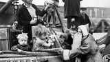 21 dicembre 1938: un uomo vestito da Babbo Natale distribuisce giocattoli ai bambini che secondono da una chiatta nel porto di Brentford, Regno Unito