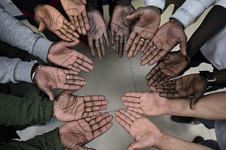 Migrant nurse Mbaye Babacar Diouf, top centre, gestures with others migrants during a workshop supporting migrants, in Bilbao, northern Spain, Wednesday, Nov. 18, 2020.