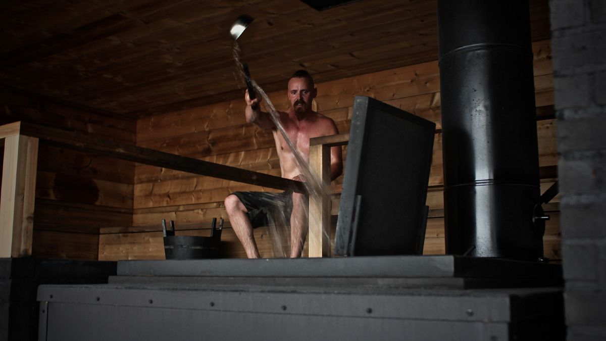 الممثل الفنلندي جاسبر باكونن يلقي بالماء على الحجارة الساخنة داخل حمام الساونا الجديدة العصرية المسماة لويلي الفنلندية في هلسنكي.