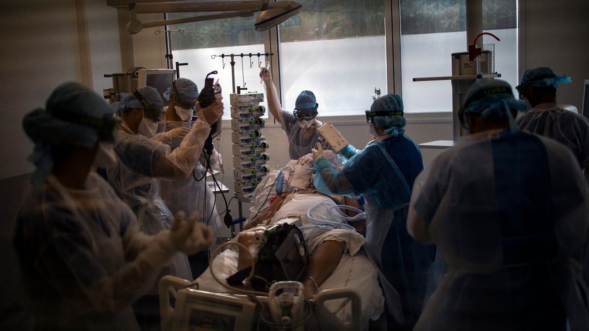 Medical workers begin installing a 60-year-old COVID-19 patient into an ICU room at the La Timone hospital in Marseille, France, Nov. 12, 2020.