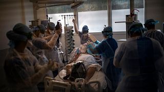 Medical workers begin installing a 60-year-old COVID-19 patient into an ICU room at the La Timone hospital in Marseille, France, Nov. 12, 2020.