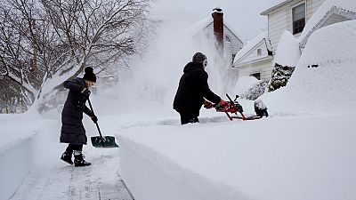 Residentes de Binghamton, estado de Nova Iorque, limpam entrada de casa após nevão