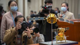 Des journalistes photographient une maquette de l'orbiteur et de l'atterrisseur lunaire chinois Chang'e-5, à Pékin, Chine, le 17 décembre 2020