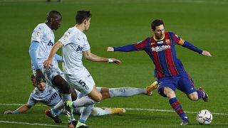 Barcelona's Lionel Messi, right, takes a shot at goal during the Spanish La Liga soccer match between Barcelona and Valencia at the Camp Nou stadium in Barcelona, Spain.