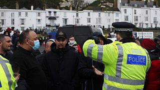 Truck drivers argue with police at entrance to the Port of Dover, that is blocked by police, as vehicles queue to be allowed to leave, in Dover, England