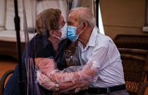  Агустина Каньямеро, 81 год, и Паскуаль Перес, 84 года, обнимаются и целуются сквозь полиэтиленовую пленку в доме престарелых в Испании. 22 июня.