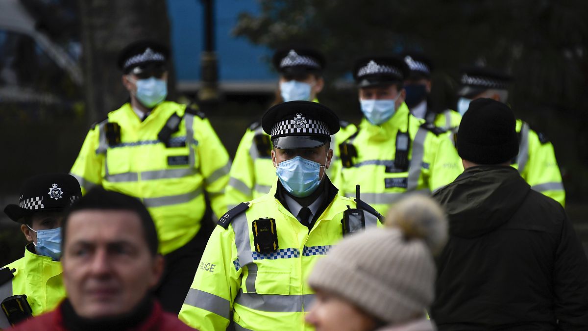 Police officers wear face masks as they patrol an anti-lockdown demonstration in Parliament Square, in London, Monday, Dec. 14, 2020. 