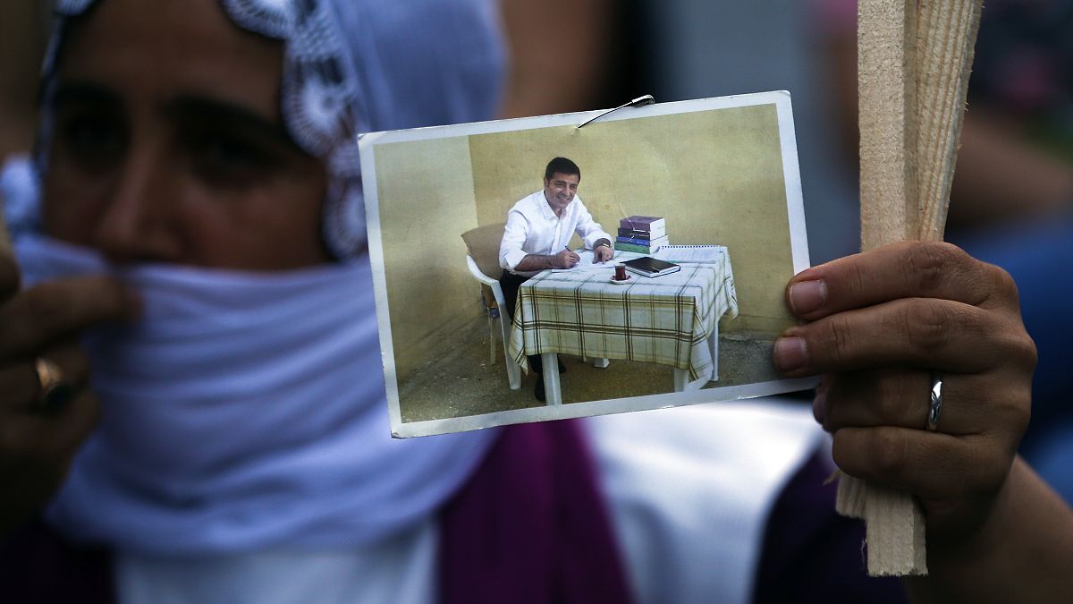 A supporter holds up a prison photograph of Selahattin Demirtaş in June 2020
