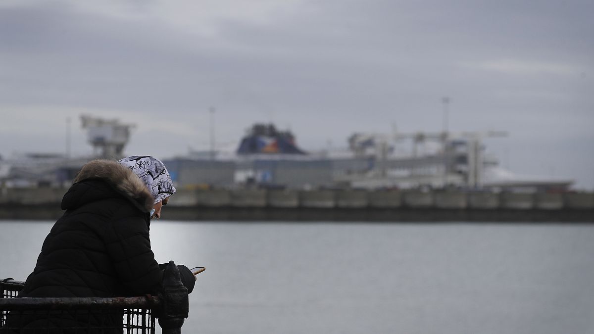 Eine Frau mit ihrem Smartphone in der Nähe des englischen Hafens Dover. Viele Briten, die in die EU reisen wollten, sitzen zu Hause fest