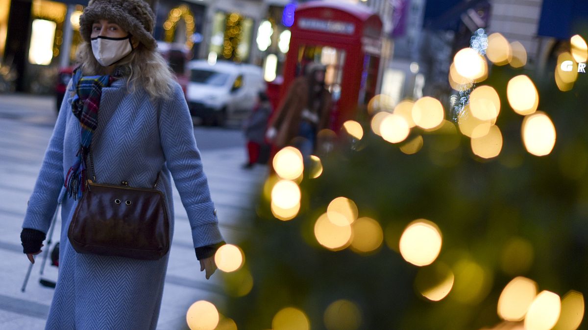 A woman wears a face mask as she walks past a Christmas tree in New Bond Street, in London, Tuesday, Dec. 22, 2020.