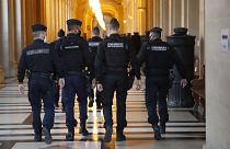 FILE: French gendarmes walk in the corridor of the hall of justice, Thursday, Dec. 17, 2020 in Paris.