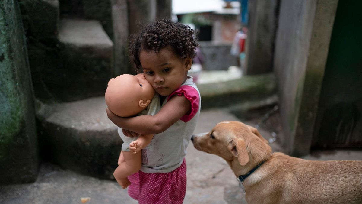 فتاة تحمل دميتها في أحد أحياء ريو دي جانيرو الفقيرة، البرازيل، الثلاثاء، 24 مارس 2020