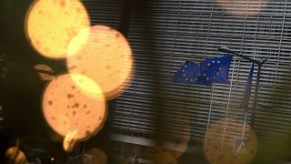 European Union flags flutter in the wind amongst Christmas decorations outside of EU headquarters in Brussels, Wednesday, Dec. 23, 2020.