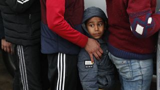 In this Tuesday, March 10, 2020 file photo, migrants wait in line for a distribution of blankets close to the Turkish-Greek border near Pazarkule, Edirne region, Turkey. 