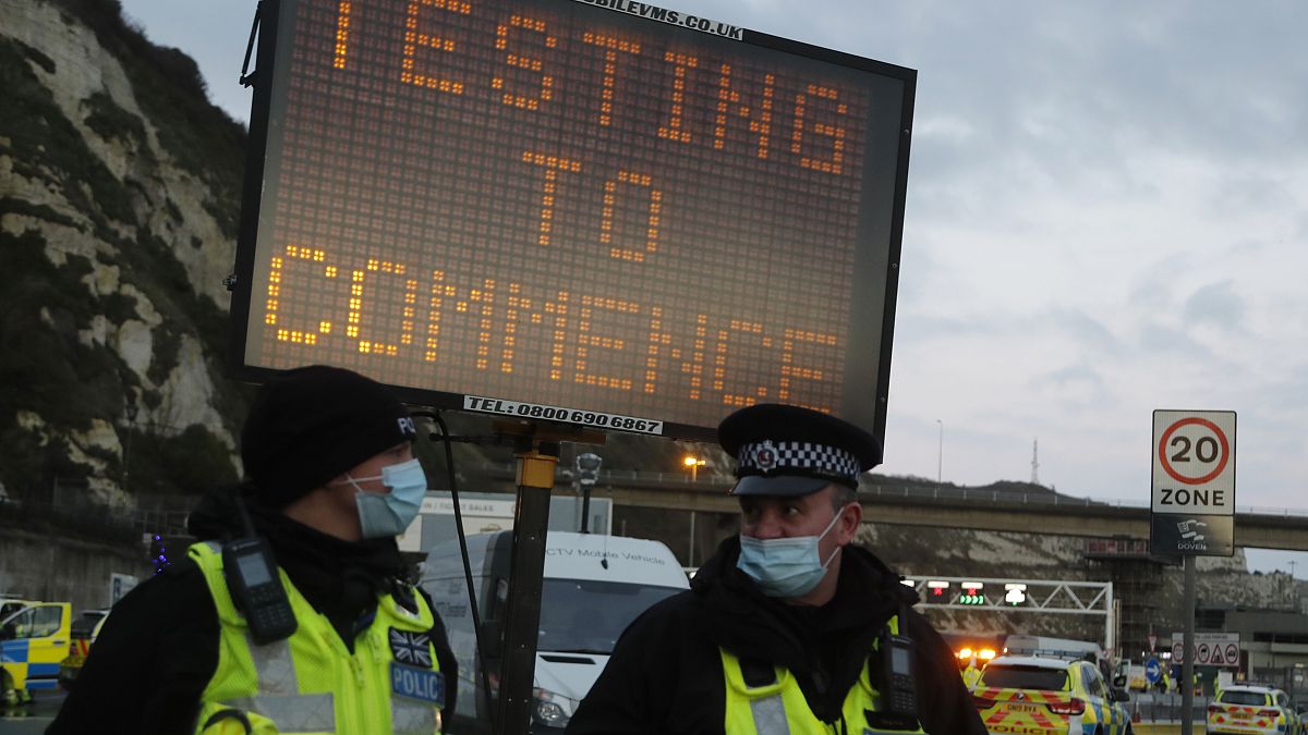 Police stand next to an electronic notice notifying about coronavirus testing to help clear a backlog of freight, truck and passengers outside the Port of Dover in Dover.