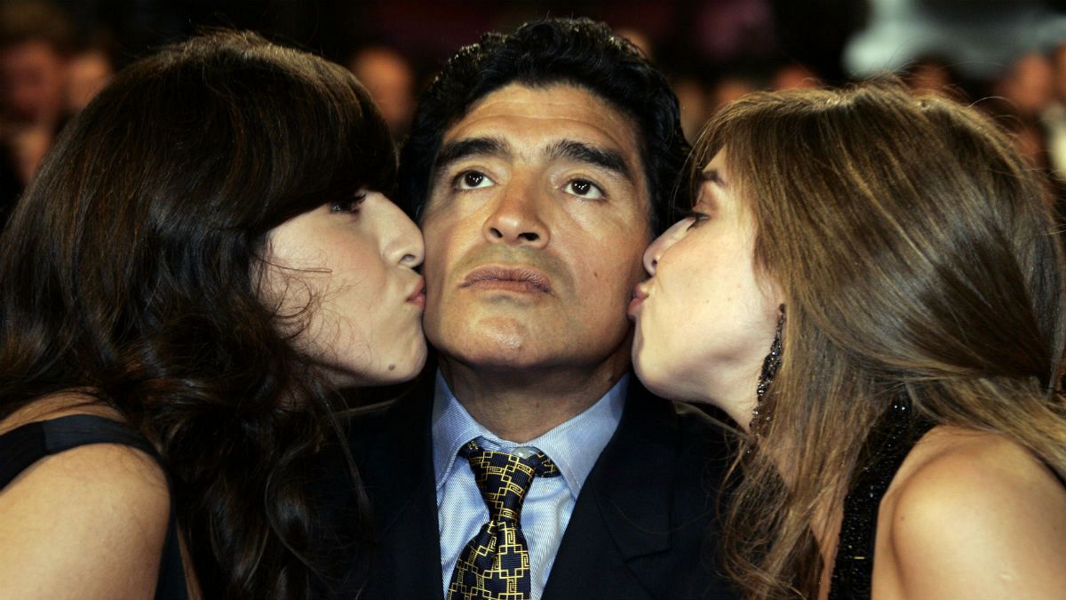 بوسه دختران دیگو مارادونا بر گونه‌های پدر؛ سمت چپ: جیانینا و سمت راست: دالما