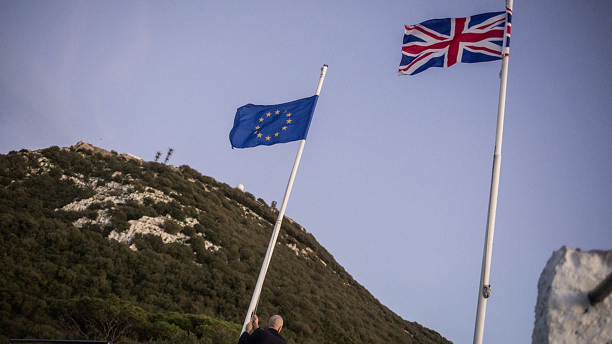 A worker lowers the EU flag at the British territory of Gibraltar, Friday Jan. 31, 2020.