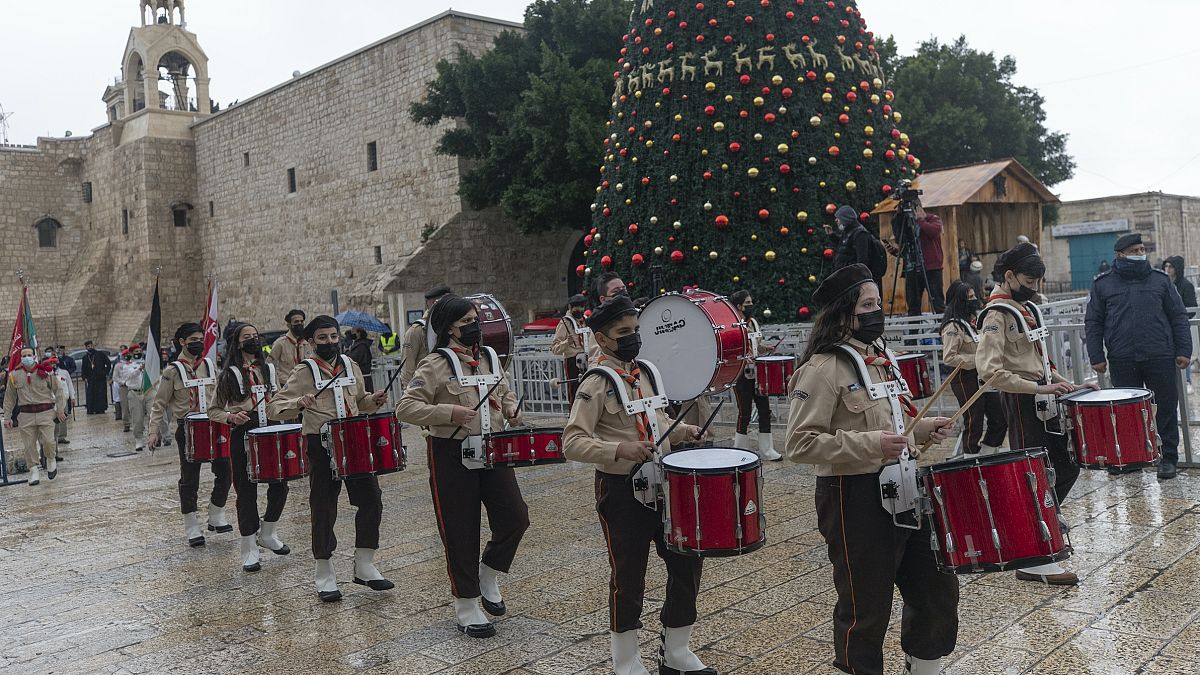 Palestinian scout bands parade through Manger Square at the Church of the Nativity, in the West Bank city of Bethlehem, Thursday, Dec. 24, 2020.