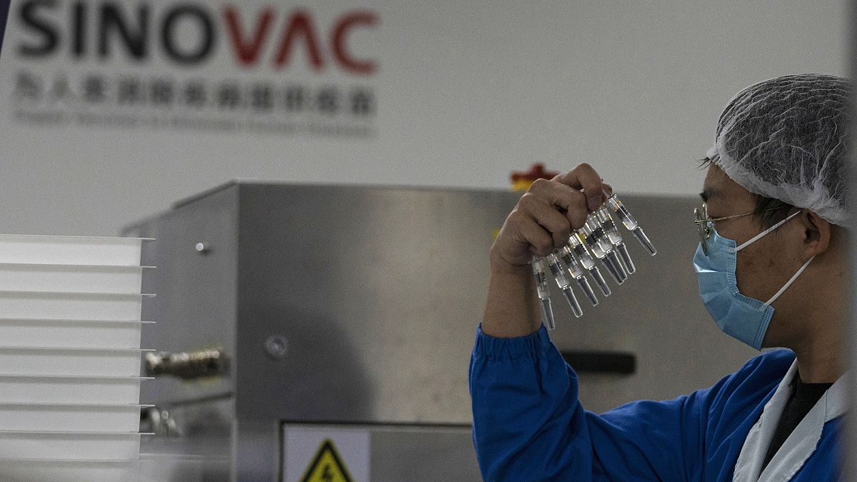 Çin'in başkenti Pekin'de bir görevli, SinoVac tarafından üretilen Covid-19 aşısının şırıngalarını incelerken