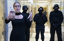 FILE - Russian opposition activist Lyubov Sobol reports live by phone as policemen stand guard at the Foundation for Fighting Corruption office in Moscow, Russia.