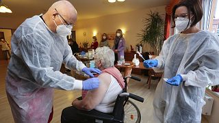 Doctor Bernhard Ellendt, left, injects the COVID-19 vaccine into a nursing home resident in Halberstadt, Germany, Saturday, Dec. 26, 2020.