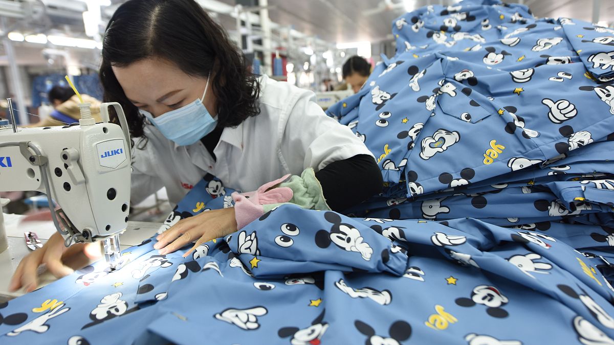A woman wearing a mask labors in a garment factory in Donghai county in east China's Jiangsu province Tuesday, Oct. 27, 2020. 