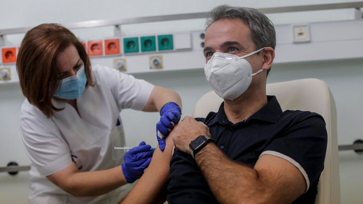 Greece's Prime Minister Kyriakos Mitsotakis, right, receives an injection with a dose of COVID-19 vaccine, at the Attikon University Hospital in Athens, Sunday, Dec. 27, 2020.